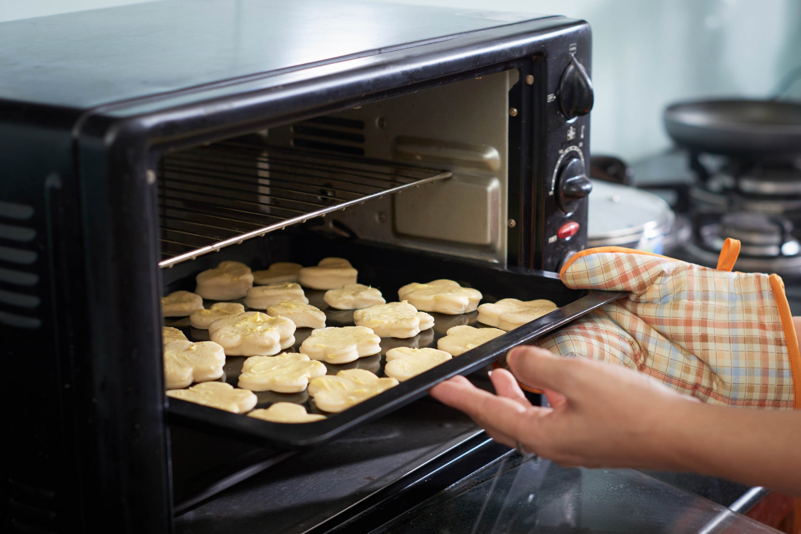 .ידיים מוציאות תבנית של עוגיות מוכנות מהתנור